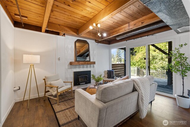 living area featuring beamed ceiling, wooden ceiling, hardwood / wood-style flooring, and a fireplace
