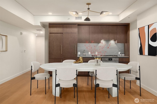 121 Stewart St Unit 905, Seattle, WA 98121 - dining area with baseboards and light wood-style flooring