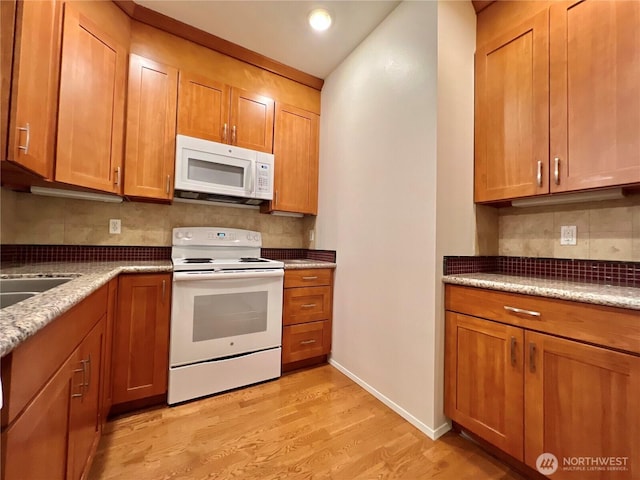 kitchen with recessed lighting, white appliances, light wood-style floors, brown cabinets, and backsplash