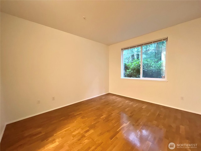 empty room featuring baseboards and wood finished floors
