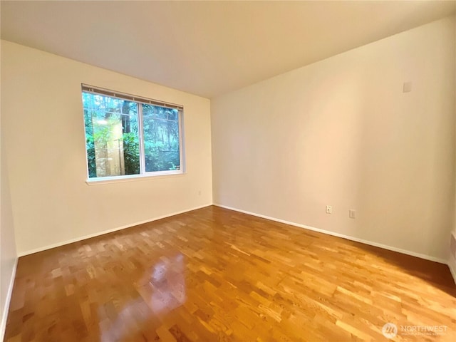 unfurnished room featuring wood finished floors and baseboards