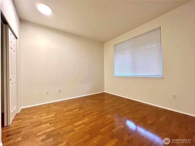 unfurnished bedroom with baseboards and wood finished floors