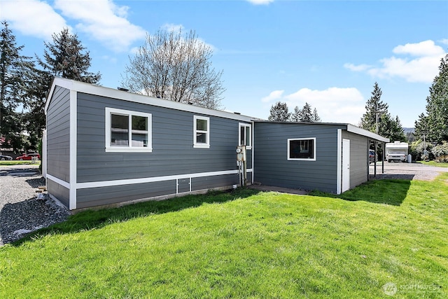 rear view of property featuring a lawn