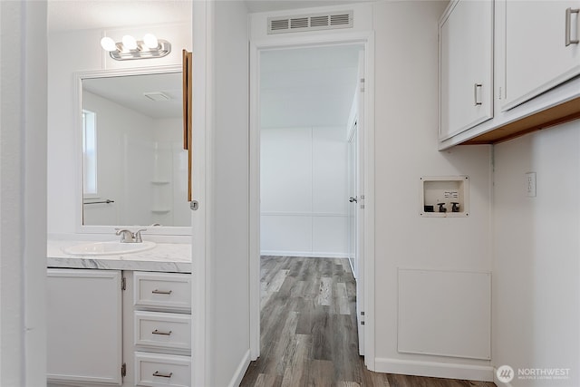 bathroom with visible vents, wood finished floors, and vanity