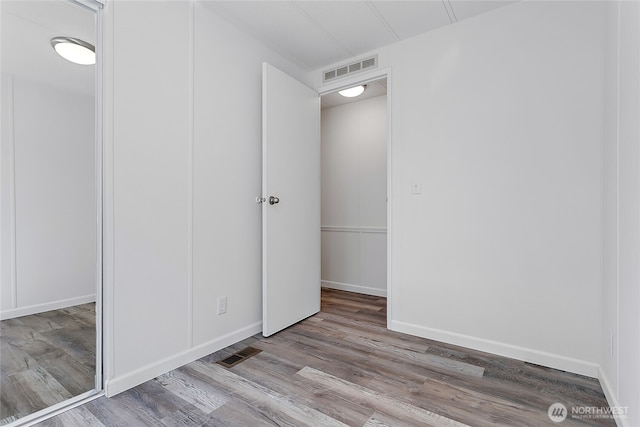 interior space featuring baseboards, visible vents, and wood finished floors