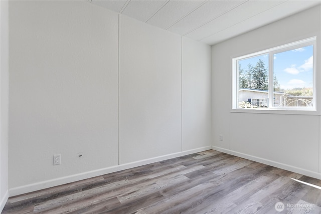 unfurnished room featuring baseboards and wood finished floors