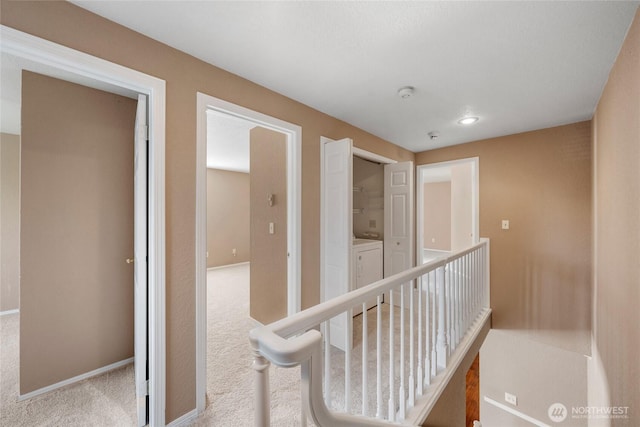 hall featuring baseboards, recessed lighting, carpet, and washing machine and dryer
