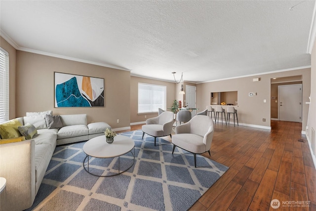 living area with crown molding, a textured ceiling, baseboards, and hardwood / wood-style flooring