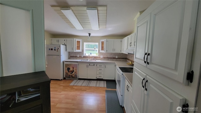 151 W Nikula Rd, Winlock, WA 98596 - kitchen with a sink, light wood-style floors, tasteful backsplash, white appliances, and white cabinets