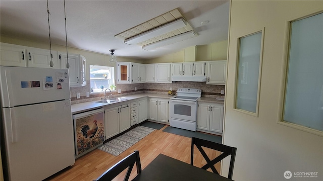 151 W Nikula Rd, Winlock, WA 98596 - kitchen featuring a sink, under cabinet range hood, backsplash, white appliances, and lofted ceiling