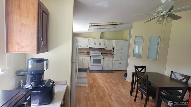 151 W Nikula Rd, Winlock, WA 98596 - kitchen with lofted ceiling, light wood-style flooring, light countertops, under cabinet range hood, and white appliances