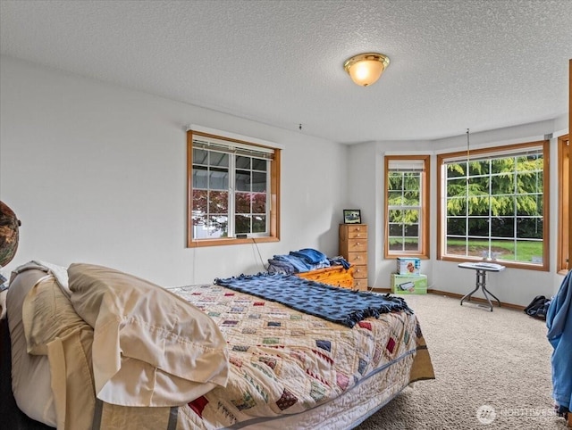 carpeted bedroom featuring a textured ceiling and baseboards