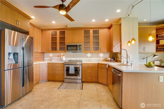 kitchen with light countertops, decorative backsplash, and appliances with stainless steel finishes