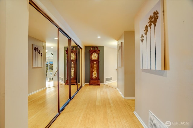 hall featuring recessed lighting, baseboards, visible vents, and light wood finished floors