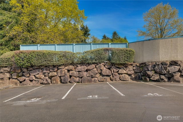uncovered parking lot featuring fence