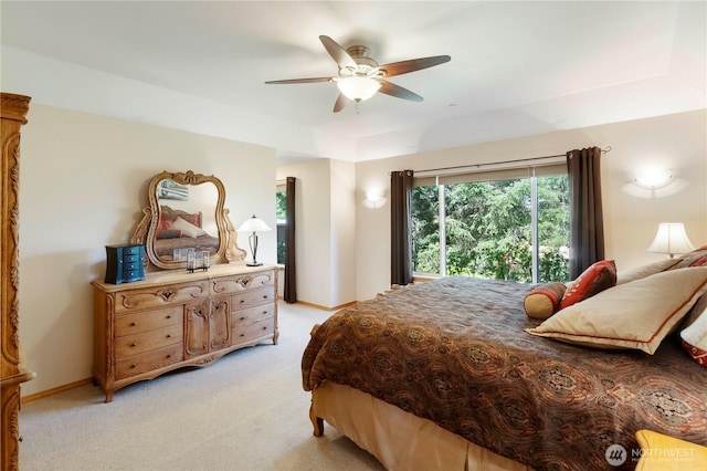 bedroom featuring baseboards, multiple windows, light carpet, and ceiling fan