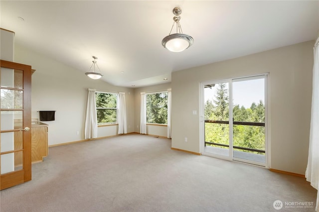 unfurnished living room with baseboards and light colored carpet