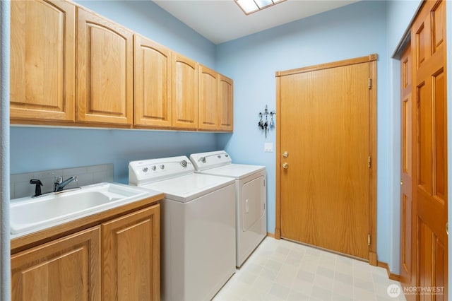 laundry room featuring light floors, a sink, cabinet space, and washing machine and clothes dryer