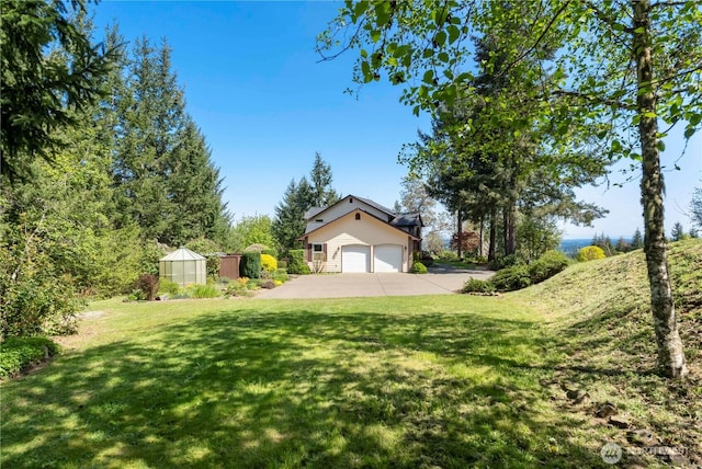 view of yard with an outdoor structure and concrete driveway