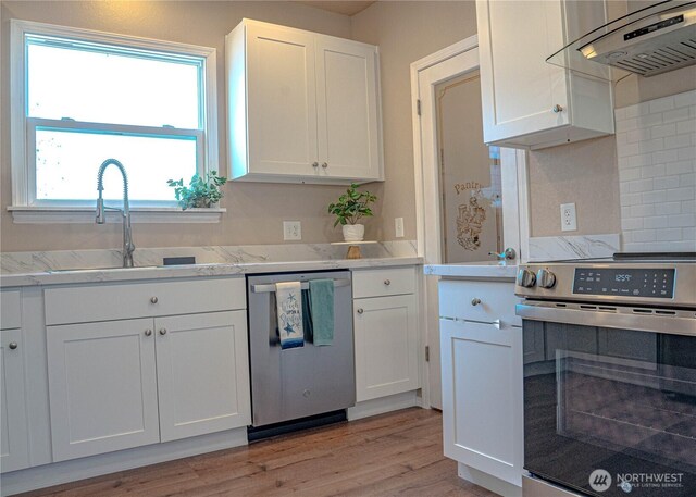 kitchen with a sink, range, white cabinetry, extractor fan, and stainless steel dishwasher