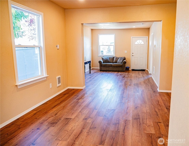 foyer featuring wood finished floors, visible vents, and baseboards