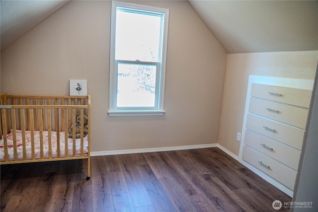 unfurnished bedroom with vaulted ceiling, wood finished floors, and baseboards