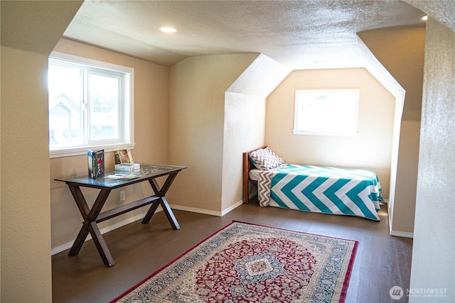 bedroom with wood finished floors, vaulted ceiling, and baseboards