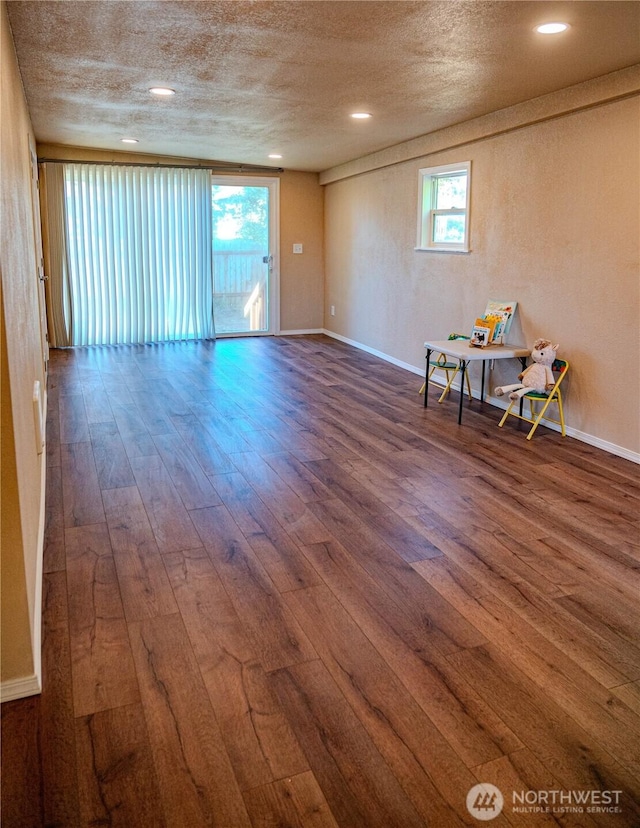 unfurnished room with wood-type flooring, recessed lighting, a textured ceiling, and baseboards