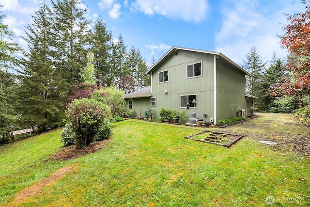 back of house with a yard and a vegetable garden
