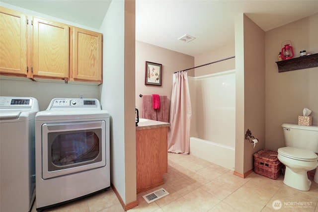 laundry area with separate washer and dryer and light tile patterned flooring