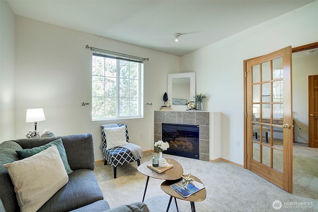 carpeted living area with baseboards and a tile fireplace