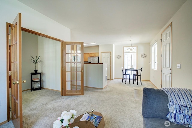 living room featuring light colored carpet, baseboards, and french doors