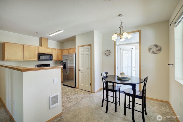 kitchen with an inviting chandelier, stainless steel fridge, light brown cabinets, baseboards, and black microwave