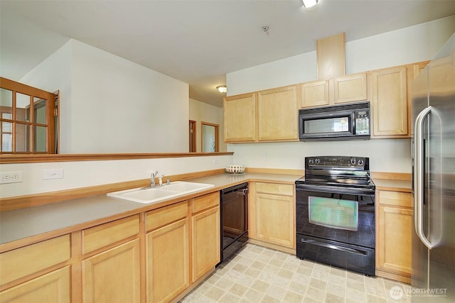 kitchen with black appliances, light countertops, light brown cabinetry, and a sink