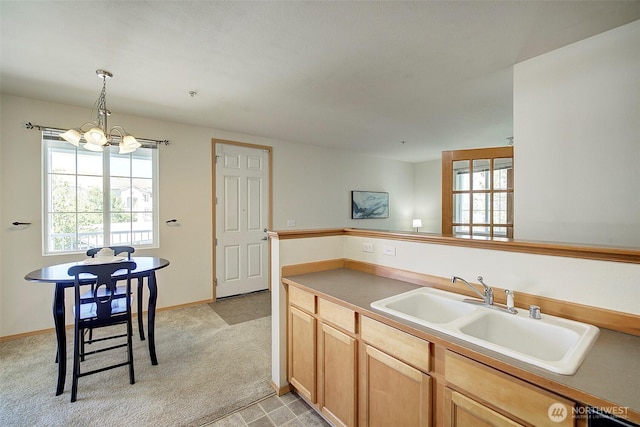 kitchen featuring a sink, a chandelier, light carpet, and plenty of natural light