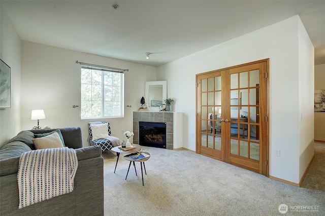 carpeted living area with a fireplace, baseboards, and french doors