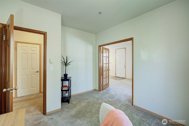 hall featuring light carpet and baseboards