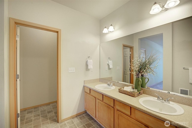 full bath featuring a sink, double vanity, baseboards, and visible vents