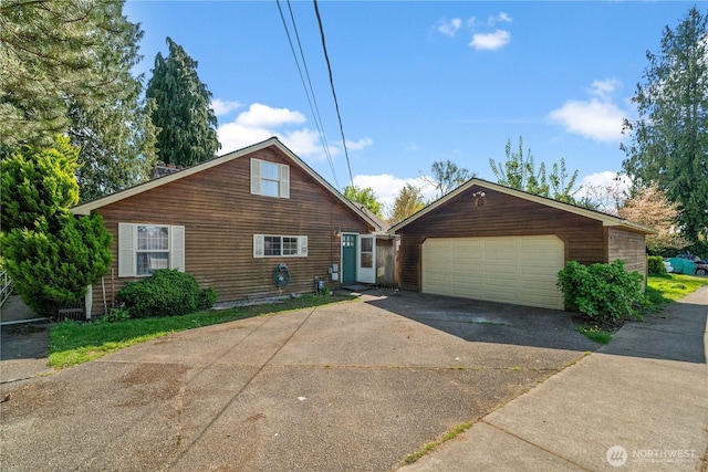 view of front of home with a garage, an outdoor structure, and concrete driveway