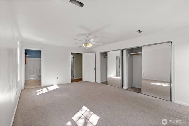 unfurnished bedroom with baseboards, ensuite bathroom, ceiling fan, and carpet flooring