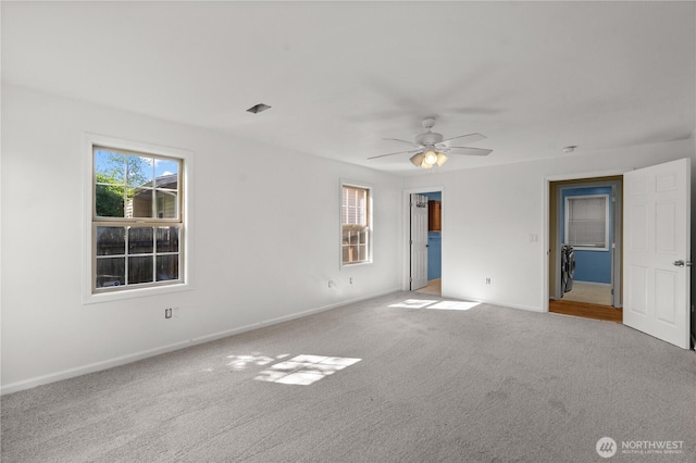 unfurnished bedroom featuring carpet, baseboards, and multiple windows