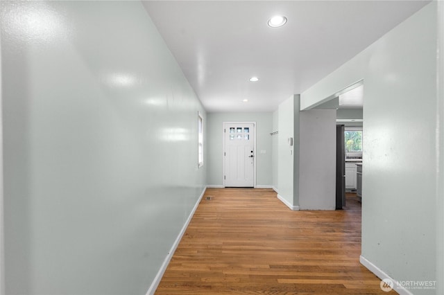 corridor with recessed lighting, wood finished floors, and baseboards
