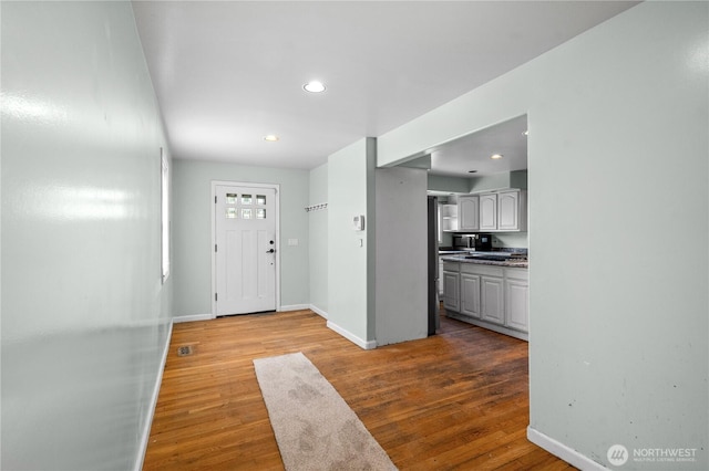 entrance foyer featuring wood finished floors, recessed lighting, and baseboards