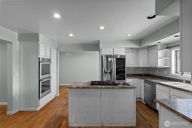 kitchen featuring white cabinets, stainless steel appliances, dark wood-type flooring, and a sink