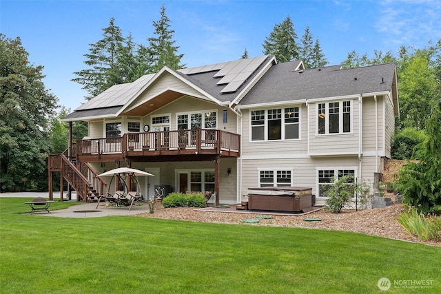 6205 139th Ln SW, Rochester, WA 98579 - back of property featuring a hot tub, a patio area, a deck, a yard, and roof mounted solar panels