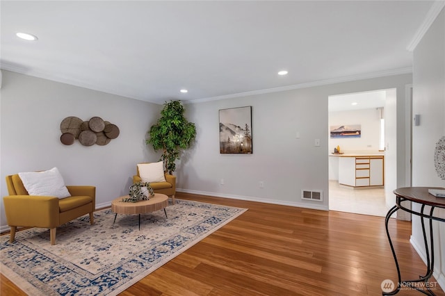 sitting room featuring recessed lighting, visible vents, ornamental molding, and wood finished floors