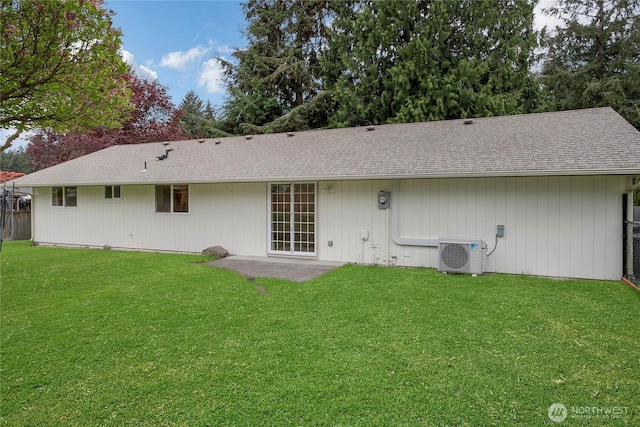 rear view of property with a lawn, ac unit, roof with shingles, and a patio area
