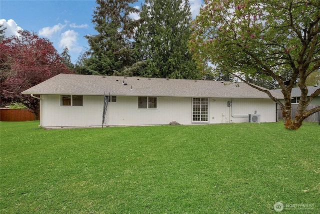 rear view of house with a lawn and fence