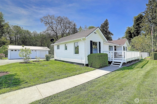 view of front of house featuring a garage, an outdoor structure, a front lawn, and a deck