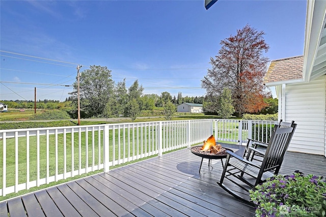 wooden terrace with a yard and an outdoor fire pit